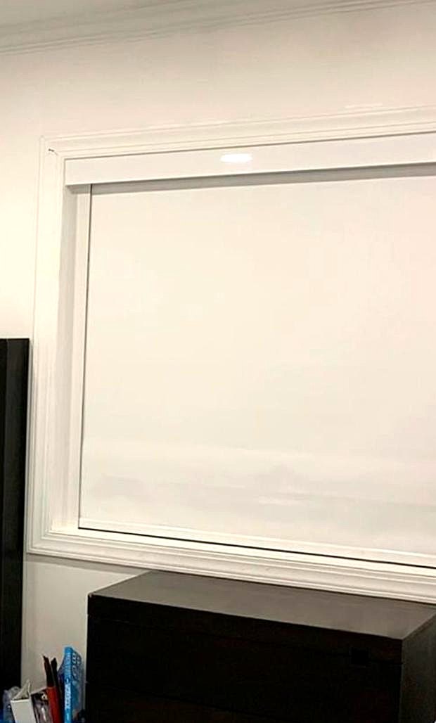 Blackout roller shade with cassette in a bedroom window