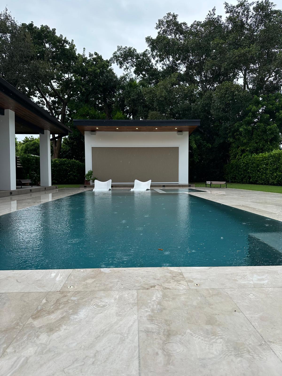 Pool house with a full-width outdoor screen shade, Miami